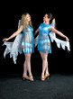 Two women in a blue dress with angel wings dance
