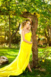 Foto: Young beautiful girl in a yellow dress in the woods Young beautiful girl in a yellow dress in the woods