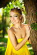 Young beautiful girl in a yellow dress in the woods