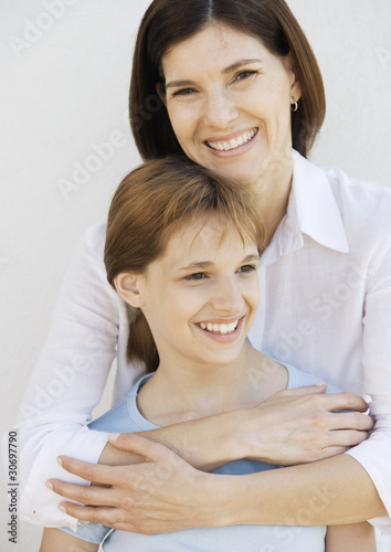 Photo: Mother with arms around preteen daughter Mother with arms around preteen daughter