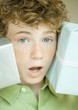 Boy holding up presents on either side of face