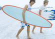 Surfers carrying surfboards