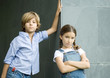 Boy and girl, leaning against corner of wall, portrait
