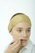 Teenage girl applying lipliner