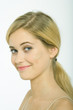Teenage girl with dollop of foundation on cheek, smiling at camera