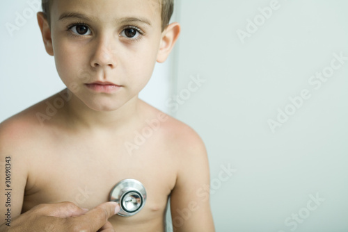 Photo: Doctor listening to boy's chest with stethoscope Doctor listening to boy's chest with stethoscope