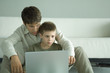 Boy and father using laptop together