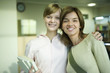 Photo: Two female college students, one with arm around the other's shoulders, smiling at camera, portrait Two female college students, one with arm around the other's shoulders, smiling at camera, portrait
