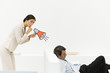 Photo: Man sleeping in chair, woman behind him holding megaphone, looking at camera, finger over lips Man sleeping in chair, woman behind him holding megaphone, looking at camera, finger over lips