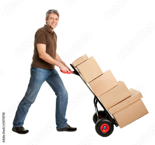 Photo: Delivery man pushing hand truck and stack of boxes Delivery man pushing hand truck and stack of boxes