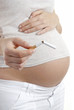 Pregnant woman holding broken cigarette