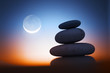 Zen stones at night over sunset sky with moon Zen stones at night over sunset sky with moon