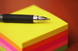 Office supplies, pen on colorful stack of sticky notes Office supplies, pen on colorful stack of sticky notes