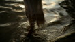 girl disappearing into the sea at sunset