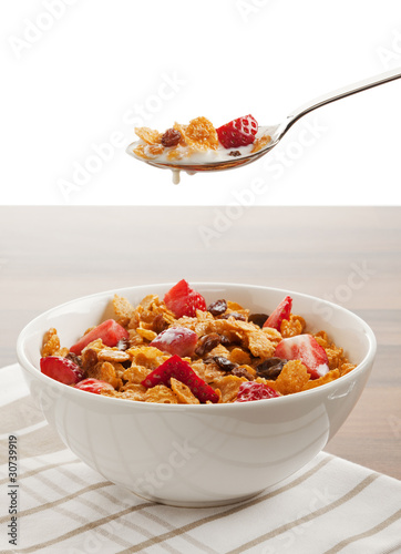 Photo: cereals and fruit with milk in bowl and on spoon cereals and fruit with milk in bowl and on spoon