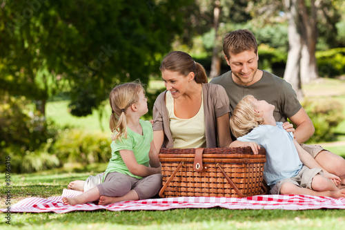Photo: Joyful family picnicking in the park Joyful family picnicking in the park