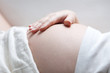 schwangere Frau mit Hand auf dem Bauch