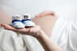 schwangere Frau mit Babyschuhen auf der Hand