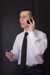 young businessman talking on two phones young businessman talking on two phones