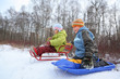 Brother and sister intend  drive from  hill in winter on sledges