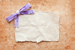 ripped piece of paper with purple bow on grunge paper background ripped piece of paper with purple bow on grunge paper background