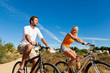 Image : Couple in holidays cycling on beach