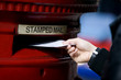 A man posting letters in a letterbox