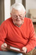 Senior Man Looking At Photograph In Frame