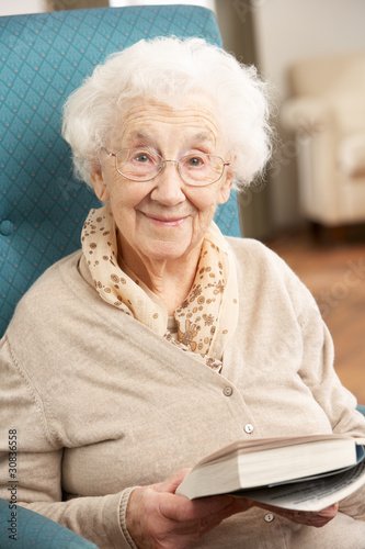Photo: Senior Woman Relaxing In Chair At Home Reading Book Senior Woman Relaxing In Chair At Home Reading Book