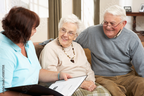 Photo: Senior Couple In Discussion With Health Visitor At Home Senior Couple In Discussion With Health Visitor At Home