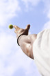 Tennisplayer trowing up a ball with his hand to serve blue sky