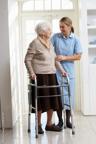 Photo: Carer Helping Elderly Senior Woman Using Walking Frame Carer Helping Elderly Senior Woman Using Walking Frame