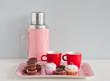 colorful modern coffee cups and home baked cupcakes on a pink se