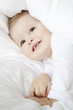 cute little boy hiding under duvet