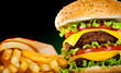 Tasty hamburger and french fries on a dark Tasty hamburger and french fries on a dark
