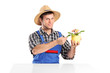 Male gardener seated next to a table cheking a flower pot