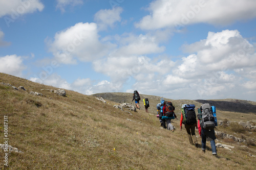Photo: Group of backpackers walking on a hill Group of backpackers walking on a hill