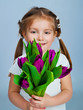 Cute little girl giving tulips