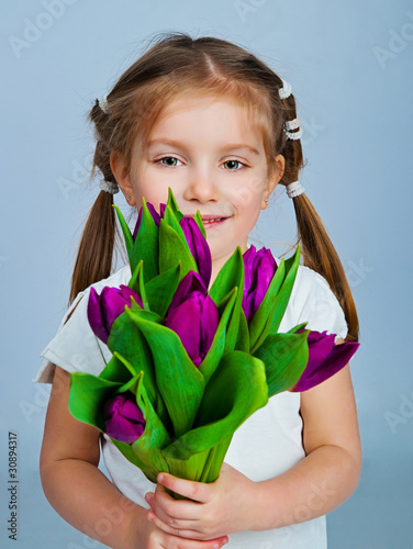 Foto: Cute little girl giving tulips Cute little girl giving tulips