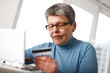 senior woman using credit card and laptop senior woman using credit card and laptop