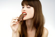 sexy woman eating a bar of chocolate - studio shot