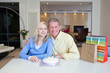 Couple celebrating birthday with birthday cake and gift bags