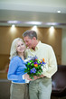 Smiling couple holding bunch of flowers