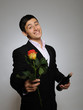 Foto: Handsome romantic young man holding rose flower and vine bottle Handsome romantic young man holding rose flower and vine bottle