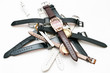 Many female`s wristwatches with leather wristlets on white