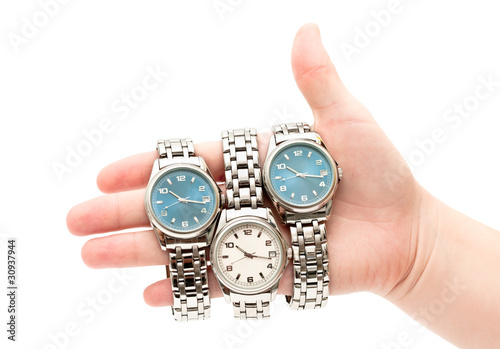 Photo: Three wristwatches on women`s hand isolated on white background Three wristwatches on women`s hand isolated on white background