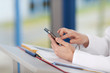 frau am stehpult tippt auf handy
