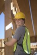 Labourer positioning plank of wood