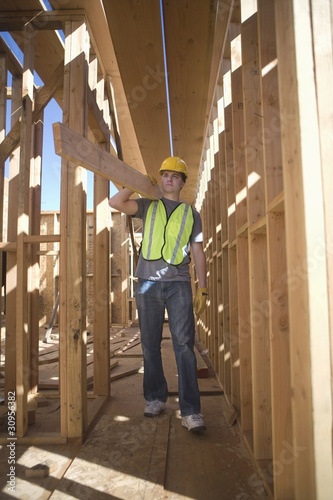 Foto: Labourer carrying plank of wood Labourer carrying plank of wood