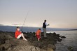 Father with two suns fishing on Paradise beach of Langebaan, South Africa